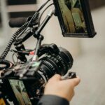 A videographer adjusts high-end filming equipment during an outdoor video production.